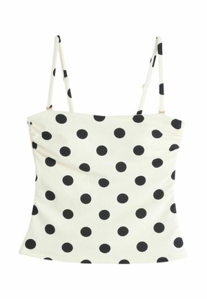 Biały krótki top na cienkich ramiączkach z czarnymi kropkami, prosty dekolt i dopasowany fason.