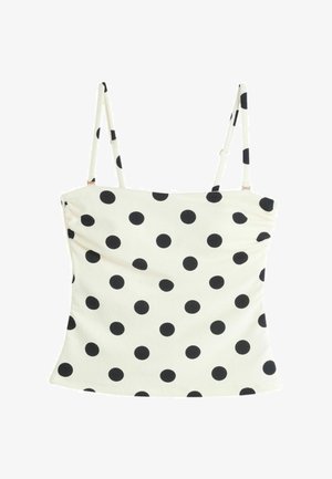 White spaghetti strap crop top with black polka dots, straight neckline, and fitted silhouette.