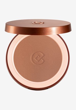 Gesloten compacte bronzer met een verhoogd logo op het poederoppervlak en een metalen bronzen deksel die gedeeltelijk openstaat tegen een witte achtergrond.