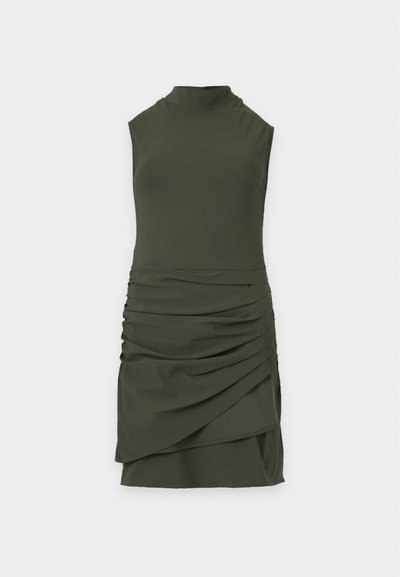 Robe mini vert foncé sans manches, à col montant et détails froncés et drapés sur la jupe, sur un fond uni clair.