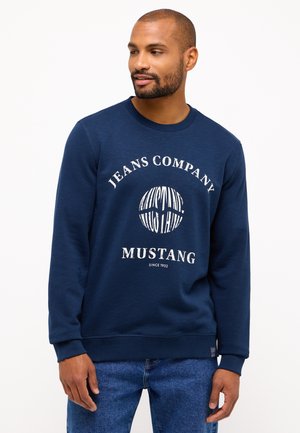Navyblauwe sweatshirt met een ronde hals, ribgebreide manchetten en een centrale graphic met "JEANS COMPANY MUSTANG" in het wit. Gemaakt van een katoenmix.