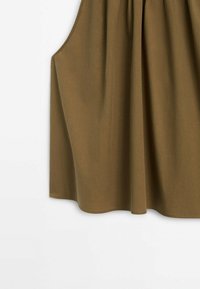 Haut sans manches marron avec une coupe ample, présentant un tissu froncé au niveau de l'encolure et une texture lisse, ourlé en bas.