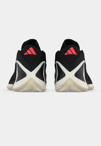 Μαύρα αθλητικά παπούτσια με υφασμάτινη υφή και αντίθετα λευκά και κόκκινα στοιχεία. Ξεχωριστό τριγωνικό λογότυπο και μοναδικό μοτίβο σόλας.