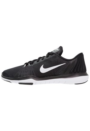 Chaussure de running Nike noire avec logo swoosh blanc, tige en mesh, lacets noirs et semelle segmentée blanche vue de profil.