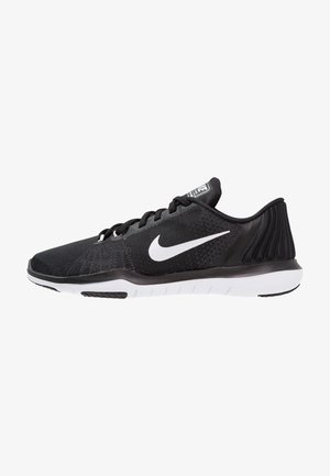 Zapatilla de running negra de Nike con logo swoosh blanco, parte superior de malla, cordones negros y suela blanca segmentada, mostrada de perfil.