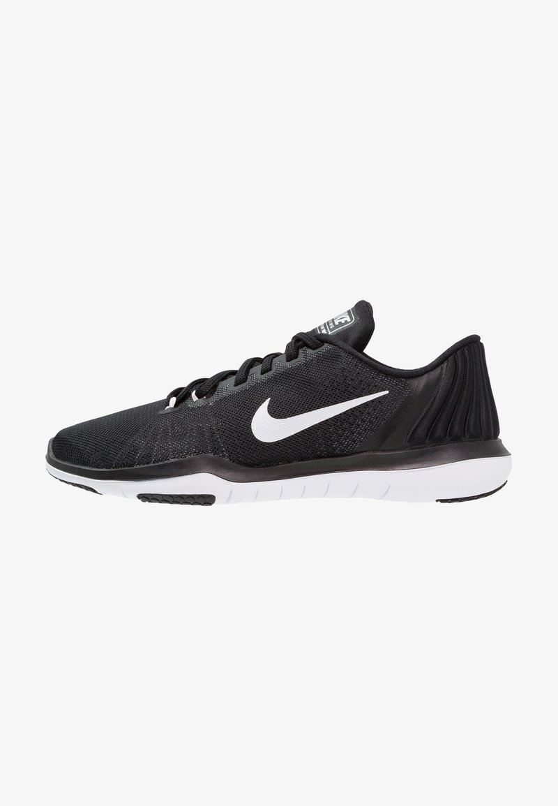 Zapatilla de running negra de Nike con logo swoosh blanco, parte superior de malla, cordones negros y suela blanca segmentada, mostrada de perfil.
