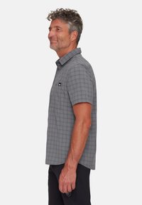 Camicetta a maniche corte grigia con motivo a quadri, dotata di colletto button-down e taschino sul petto con una patch del logo. Texture del tessuto morbida.