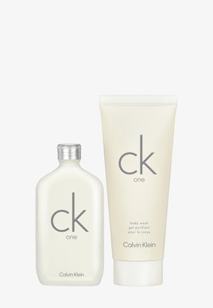 Conjunto de gel de ducha CK One de Calvin Klein que presenta un bote claro y redondo con tapa plateada y un tubo blanco con texto gris sencillo.