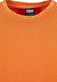T-shirt en coton orange à col rond avec un col côtelé et une texture lisse. L'étiquette indique "URBAN CLASSICS", taille S, fabriqué au Bangladesh.