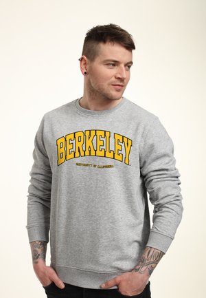 Grauer Sweatshirt mit gelber Schrift, die "BERKELEY" und "UNIVERSITY OF CALIFORNIA" liest. Hat gerippte Bündchen und einen runden Ausschnitt.