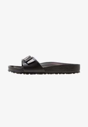 Svart slidesandal i syntetiskt material med en texturerad sula, med en bred rem och två justerbara spännen.