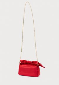 Κόκκινη τσάντα από σατέν με ορθογώνιο σχήμα, διακοσμημένη με φιόγκο στην κορυφή και μακρύ χρυσό αλυσίδα για το λουρί. Λείο υλικό με ελάχιστα σχεδιαστικά στοιχεία.