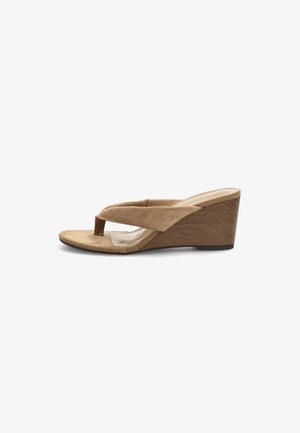 Sandalia con cuña de ante beige con tira separadora de dedos y correa acolchada, con tacón de textura de madera y diseño abierto en la punta.
