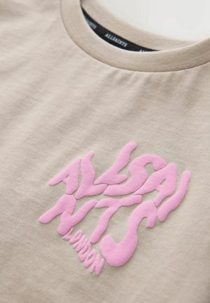 Tricou bej cu text roz în relief „AllSaints London” într-un font îndrăzneț, ondulat, pe zona pieptului.
