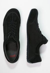 Svarta sneakers med en kombination av mocka och meshmaterial, med snörningsdesign och en låg gummisula.