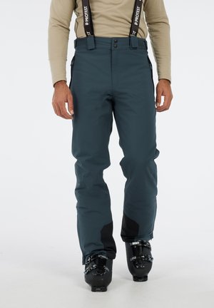 Water-resistant snow pants in dark teal with adjustable suspenders, front buttons, zippered pockets, and reinforced black accents at cuffs.