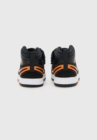 Sneaker alte nere e arancioni con tomaia in pelle, colletto imbottito e suola in gomma con battistrada testurizzato.