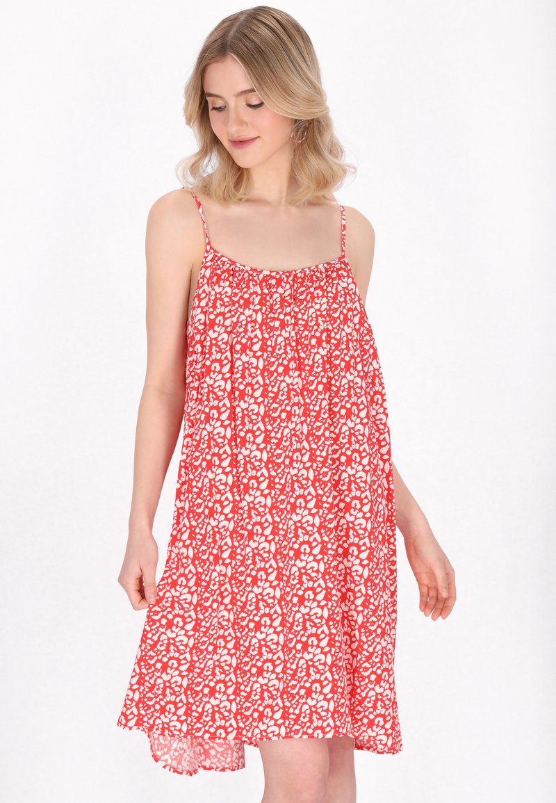 Rochie de vară roșie cu flori, cu bretele subțiri, croială lejeră și bust gathered. Materialul prezintă modele florale albe pe întreaga suprafață.