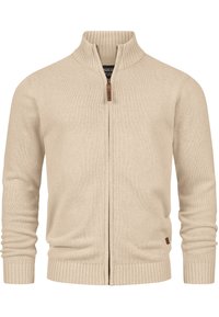 Cardigan beige à fermeture éclair en maille douce. Présente un col, des poignets et un ourlet côtelés, avec un accent en cuir sur la tirette de la fermeture éclair.