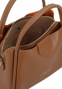 Borsa a mano in pelle color tan con una finitura testurizzata, scomparti con zip e dettagli in hardware dorato. Presenta due manici superiori.