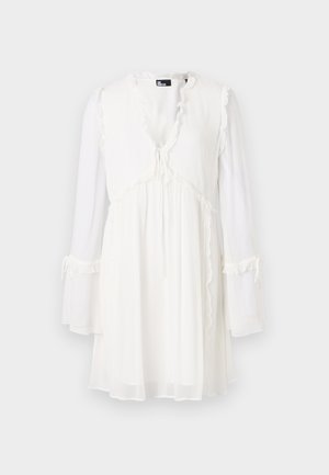 Robe blanche à manches longues avec un décolleté en V, des garnitures volantes et un lien à serrer à la taille. Fabriquée en tissu léger et transparent.