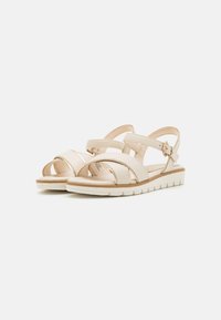 Beige leather sandals with wide crisscross straps, adjustable ankle buckle, cushioned footbed, and textured rubber sole for grip.