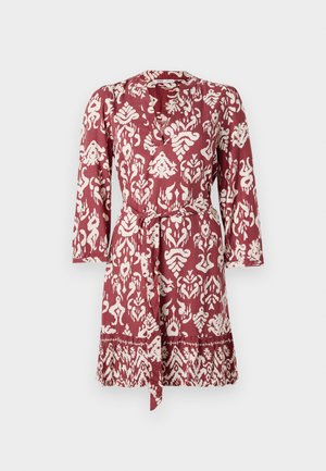 Rød og hvit mønstret kjole med belte i livet, lange ermer og v-hals. Har et intrikat blomster- og geometrisk design.