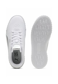 Chaussures de sport blanches avec une tige synthétique, une semelle intercalaire texturée, une semelle extérieure en caoutchouc, une fermeture à lacets et des accents argentés réfléchissants.