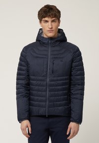 Marineblaue Steppjacke mit Kapuze, mit einem Reißverschluss und Slim Fit. Horizontales gestepptes Muster mit einer Brusttasche und elastischen Bündchen.