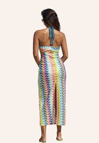 Mehrfarbiges Maxikleid mit Zickzackmuster, figurbetontem Oberteil, Rückenschnürung und einem hohen Schlitz bis zum Oberschenkel. Aus leichtem Material gefertigt.