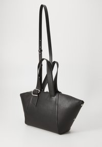 Black leather bag with a structured, angular design. Features two handles and an adjustable strap. Silver hardware accentuates the edges.
