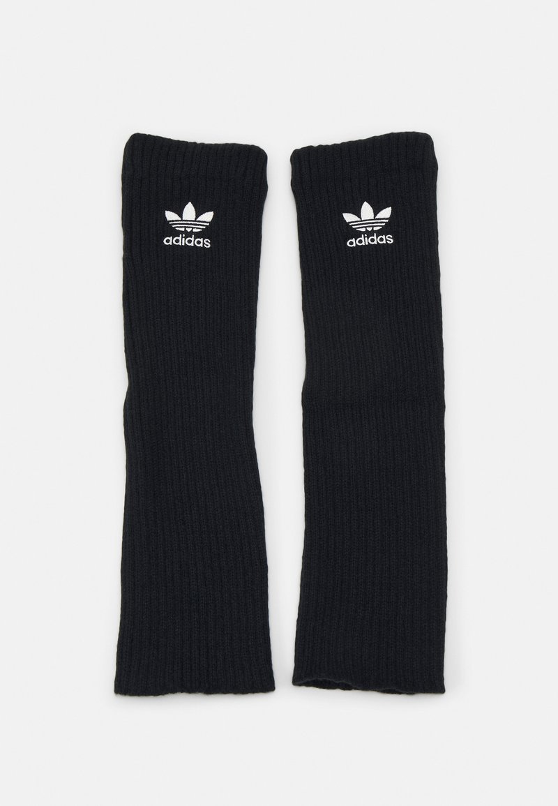 Μαύροι ριγέ καλσόν ζεστά ποδιών από απαλό υλικό, με λευκό λογότυπο Adidas και εμβληματικό σχέδιο τριών λωρίδων στο πάνω μέρος.