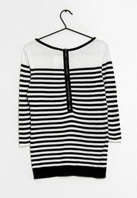 Gestreifter Pullover in Schwarz und Weiß mit rundem Halsausschnitt, langen Ärmeln und einem schwarzen Reißverschlussdetail auf der Rückseite. Hergestellt aus einem weichen Strickstoff.