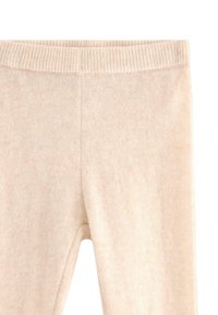 Beige strikkede leggings med en bred, struktureret talje og glat, blød stof med subtile farvevariationer.