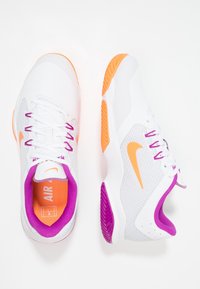 Sneakers Nike z białą cholewką, pomarańczowymi akcentami, purpurowymi detalami na kołnierzu i podeszwie oraz teksturowaną powierzchnią dla lepszego chwytu.