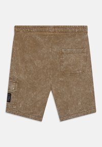 Bruine gewassen stoffen shorts met elastische tailleband, achterste rechter zak met flap, en een kleine zijzak met zwarte label op het linkerbeen.