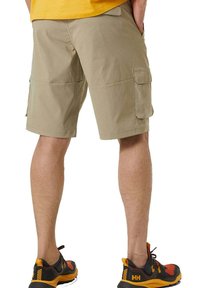 Khaki cargoshorts met meerdere zijzakken, een relaxte pasvorm en een lengte tot halverwege de dij, gecombineerd met zwart en oranje sportschoenen.