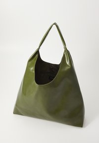 Olive green leather tote bag with a smooth texture, slouchy shape, and a single handle. Interior features a snap closure.