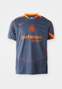 Maillot de football bleu marine avec des accents orange, doté d'un col rond, de manches courtes et d'un logo sur le devant. Fabriqué en tissu respirant.