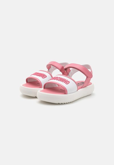 Rosa och vita sandaler med en kraftig vit sula, med justerbara remmar och broderat varumärke på framsidan.