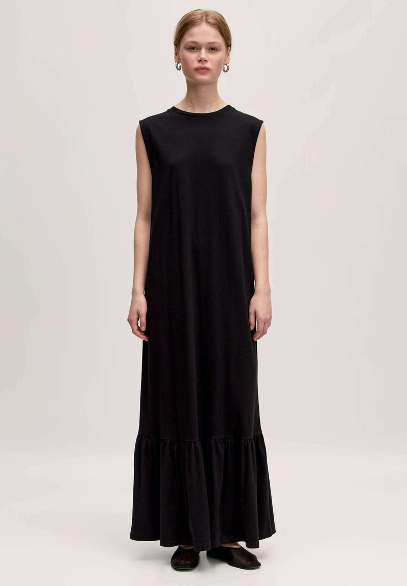 Schwarzes ärmelloses Maxikleid aus weichem Stoff, mit einem Rüschensaum und einer lockeren Silhouette. Einfacher runder Ausschnitt und knöchellanges Design.