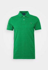 Polo verde in cotone, con colletto, patta con due bottoni e un piccolo logo ricamato sul petto. Maniche corte, texture liscia.