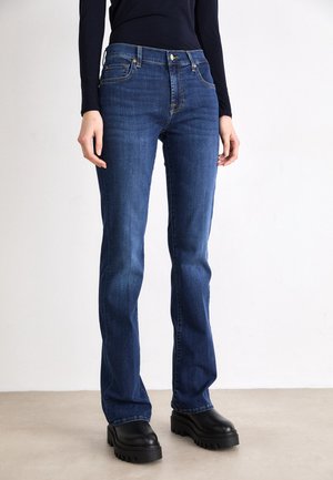 Temno modri ravni vrazkani jeans iz denima, ki imajo sprednje žepe, zlat šiv in klasičen zip s pritiskom.