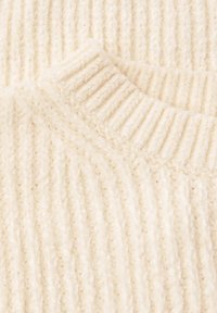 Dettaglio di un maglione beige a maglia con trama a costine verticali, caratterizzato da un collo a giro e un materiale morbido e soffice.