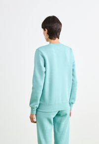 Lichtblauwe sweater gemaakt van zachte stof, met ribgebreide manchetten en zoom, een ronde halslijn en een relaxte pasvorm. Gecombineerd met bijpassende broek.