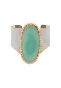 Bracciale a manica in argento con una grande pietra ovale verde, bordata in oro con un bordo texture. Superficie metallica liscia e design aperto.