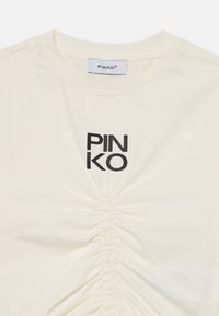 Kremfarget T-skjorte med rund hals, samlet tekstur i midten, og en svart "PINKO" logo trykket på brystet.