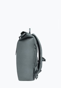 Sac à dos roll-top gris en tissu durable, doté de bretelles rembourrées, d'un design épuré et d'une poche latérale zippée sécurisée.