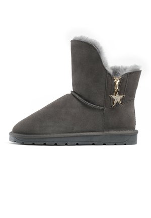 Donkergrijze suède enkellaars met een pluche binnenvoering, vlakke zool en een gouden ritssluiting met een stervormige bedel aan de zijkant.