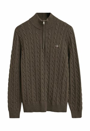 Dunkelbrauner Strickpullover mit hohem, geripptem Kragen und halbem Reißverschluss. Besitzt ein strukturiertes Zopfmuster über die gesamte Fläche.